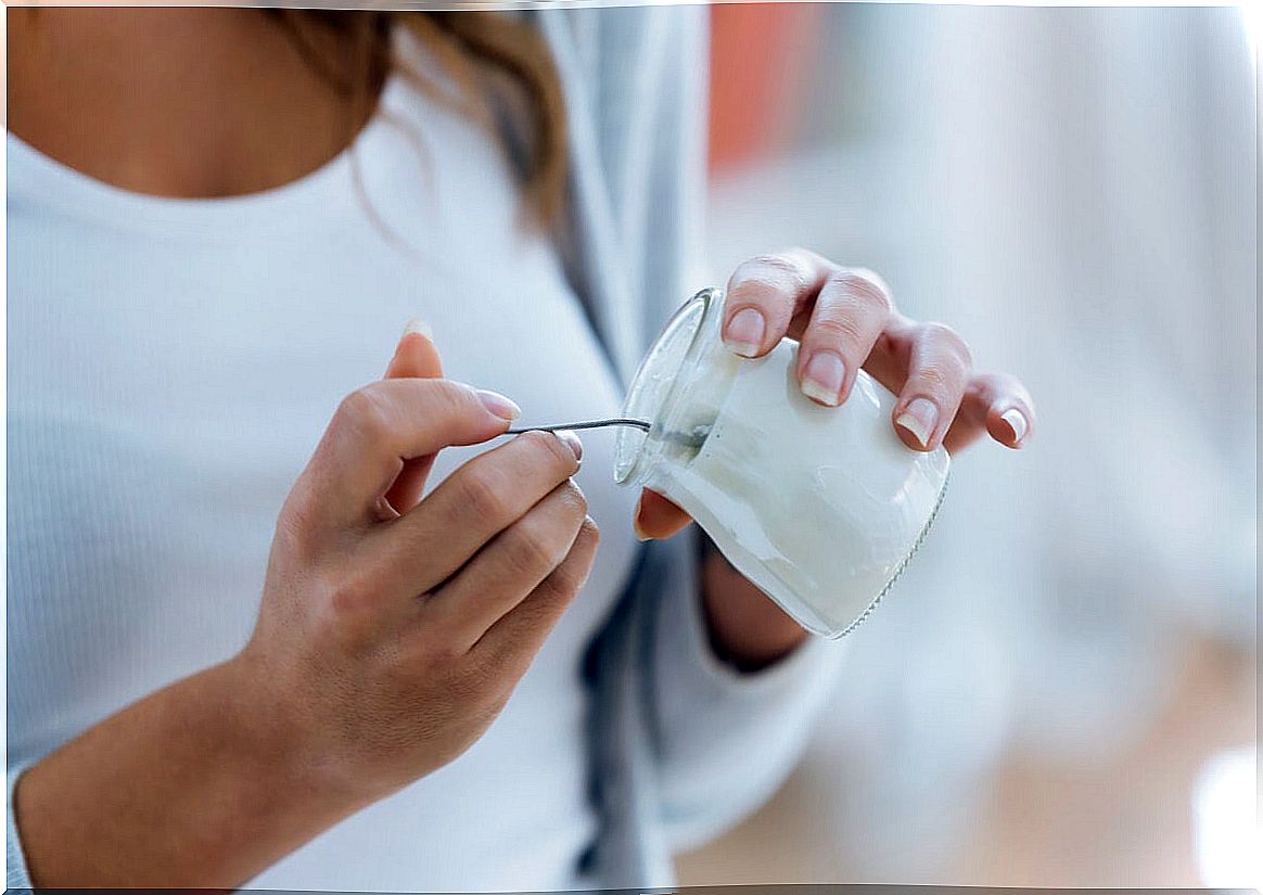 Woman eating natural yogurt.