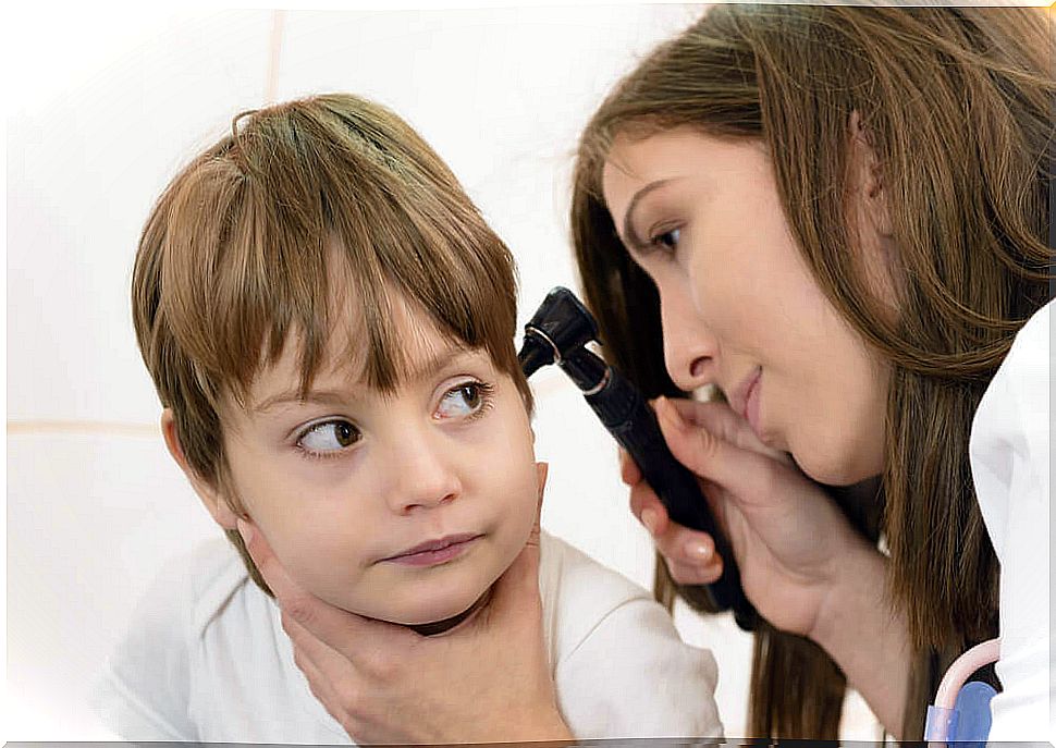 Female doctor observing a child's ear